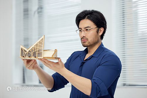 建筑設(shè)計師手拿建筑模型研究
