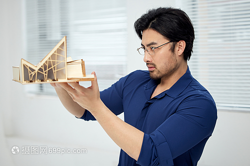 建筑設(shè)計師手拿建筑模型研究